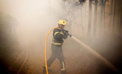 Un bombero trabaja este domingo en el incendio de Pazos de Bord&eacute;n (Pontevedra).