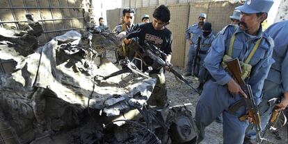 Varios agentes afganos revisan los restos del coche bomba que los suicidas han estrellado contra el edificio de la ONU en Herat.