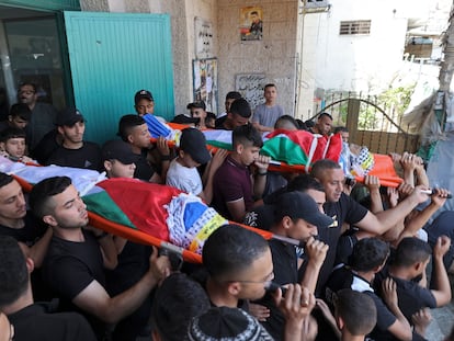 Un grupo de palestinos trasladan los cadáveres de dos hombres que murieron mientras manipulaban explosivos, el miércoles en el campo de refugiados de Balata, Cisjordania.