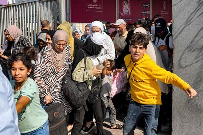 People walk through a gate to enter the Rafah border crossing to Egypt in the southern Gaza Strip on November 1, 2023.