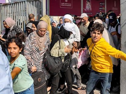 People walk through a gate to enter the Rafah border crossing to Egypt in the southern Gaza Strip on November 1, 2023.