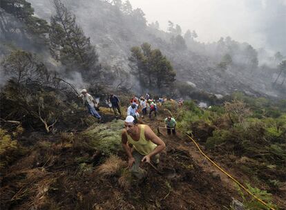 Retenes y voluntarios, en las labores de extinción del incendio de El Arenal, Ávila. El 55% del territorio español está ocupado por masa forestal. El 66,5% de los montes son de titularidad privada.