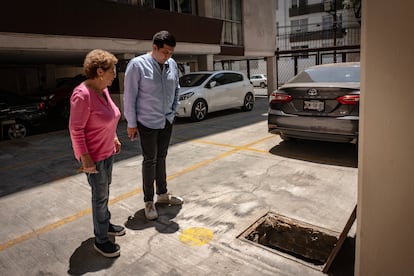 Juana Sánchez y Elí Bucio observan la cisterna llena de agua contaminada.