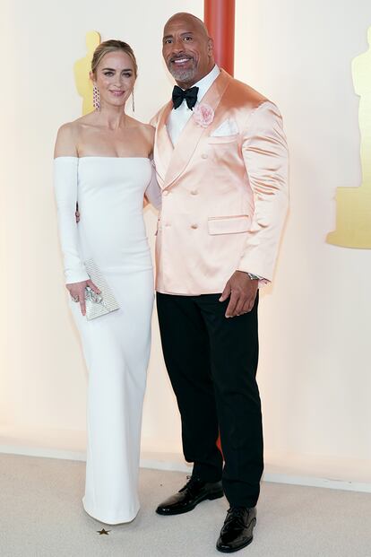 Emily Blunt y Dwayne Johnson, juntos a su llegada a la ceremonia. Ella, con un sobrio Valentino blanco y él con una flor rosa en la solapa, a juego con su chaqueta de satén. Su look es de Dolce & Gabbana.