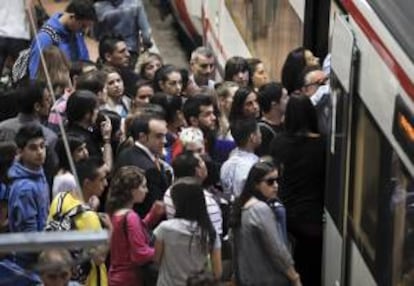 Numerosos pasajeros esperan para entrar en un tren, en la madrileña estación de Atocha. EFE/Archivo