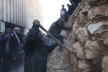 Varias personas intentan romper un muro de la prisión de Saidnaya, donde miles de personas fueron detenidas y torturadas por el régimen de Bachar el Asad durante la última década.