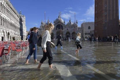 La gente camina en una inundada plaza de San Marcos en Venecia, Italia.