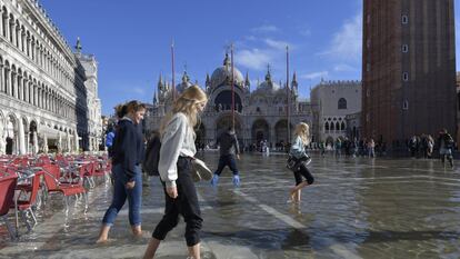 La gente camina en una inundada plaza de San Marcos en Venecia, Italia.