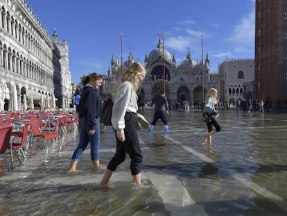 La gente camina en una inundada plaza de San Marcos en Venecia, Italia.