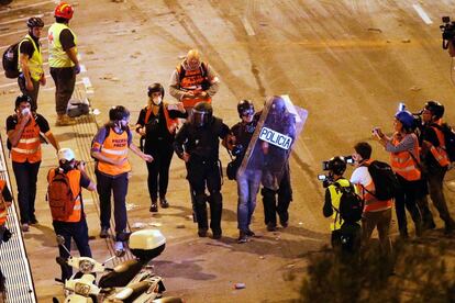 Dos policías detienen al fotoperiodista de EL PAÍS Albert Garcia durante los disturbios de la noche de este viernes en Barcelona. Garcia fue liberado hacia las 3.30 de este sábado.