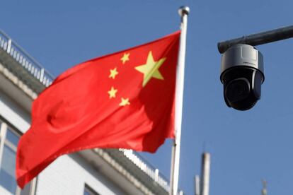 FILE PHOTO: A security surveillance camera overlooking a street is pictured next to a nearby fluttering flag of China in Beijing, China November 25, 2021. Picture taken November 25, 2021. REUTERS/Carlos Garcia Rawlins/File Photo