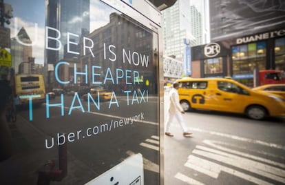 Publicidad de Uber en el centro de Nueva York. Al fondo, dos taxis