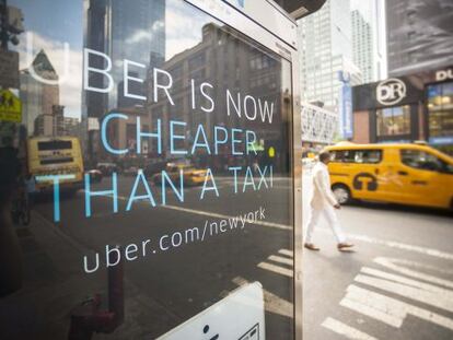 Publicidad de Uber en el centro de Nueva York. Al fondo, dos taxis