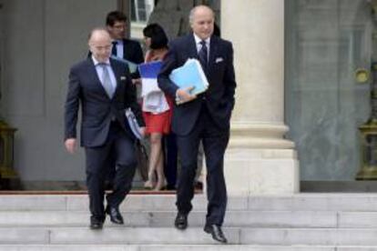 El ministro francés de Asuntos Europeos, Bernard Cazeneuve (i) y el ministro francés de Exteriores, Laurent Fabius (d), salen ayer del Palacio del Elíseo tras asistir a la reunión semanal del gabinete galo en París, Francia.