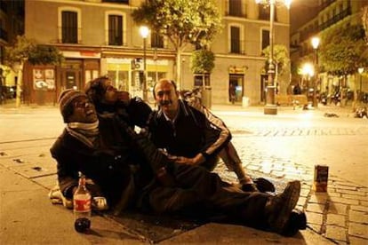 De izquierda a derecha, Héctor David González, Tomás Martínez y Pedro Alonso, sentados sobre un respiradero del metro en la plaza de Lavapiés.