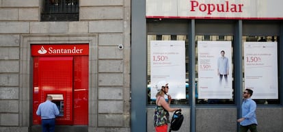 Imagen de un cajero del Banco Santander junto a una sucursal del Popular