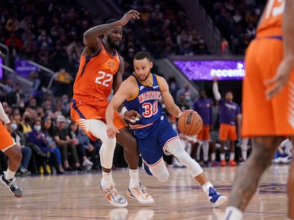 Stephen Curry finta sobre Deandre Ayton en el partido entre Golden State y Phoenix.