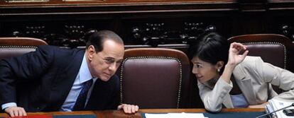Berlusconi conversa en el Parlamento con su ministra de Igualdad de Oportunidades, Mara Carfagna, durante la investidura del Gobierno el 14 de mayo.