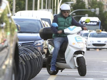 Un usuario de una moto eléctrica compartida, en una calle de Madrid.