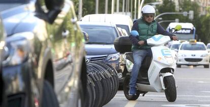 Un usuario de una moto eléctrica compartida, en una calle de Madrid.