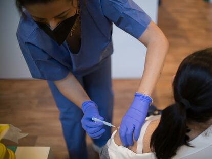 Una sanitaria vacuna a una mujer, este viernes en Sevilla.