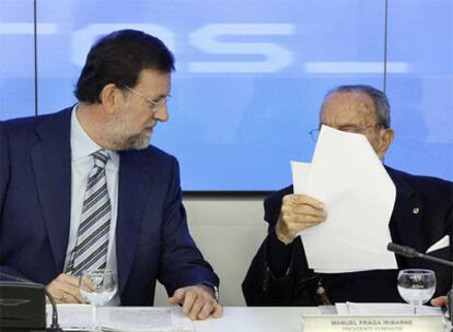 Mariano Rajoy y Manuel Fraga (que lee unos papeles), durante el comité ejecutivo.