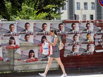 a mujer pasa frente a carteles electorales del partido Unión Socialdemócrata de Macedonia, este martes en Skopje.