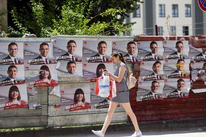 a mujer pasa frente a carteles electorales del partido Unión Socialdemócrata de Macedonia, este martes en Skopje.