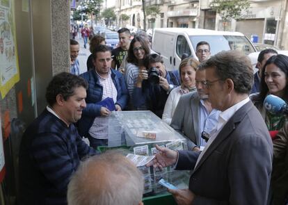 El presidente de la Xunta, y candidato a la reelección, Alberto Núñez Feijóo, compra un cupón en Santiago de Compostela, durante el paseo dentro de la campaña electoral para las elecciones gallegas. 