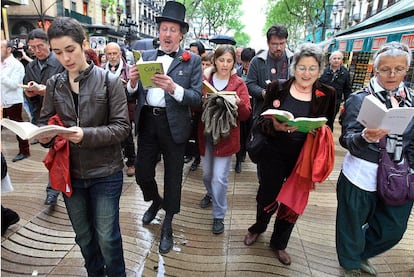 Participantes en el desfile del <i>Ramblaparaules</i> leyendo bajo la lluvia.