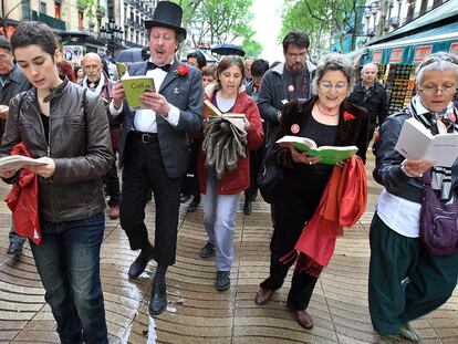 Participantes en el desfile del <i>Ramblaparaules</i> leyendo bajo la lluvia.