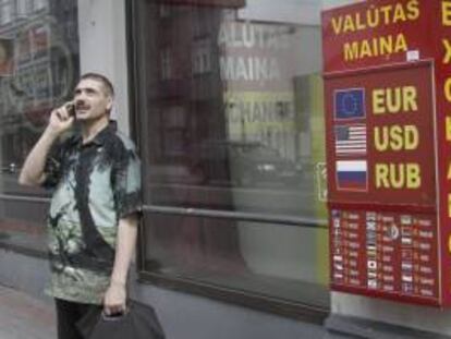 Un hombre habla por teléfono junto a una oficina de cambio de moneda en Riga (Letonia). EFE/Archivo