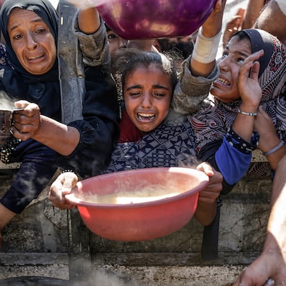 Gaza City (-), 04/08/2025.- Internally displaced Palestinians, including children, hold pots as they gather to receive food from a charity kitchen, in Gaza City, Gaza Strip, 04 August 2025. Humanitarian organizations have warned of an imminent food catastrophe for thousands of children, a crisis caused by severe food insecurity, a decline in health services, and ongoing restrictions on humanitarian aid and essential supplies. EFE/EPA/MOHAMMED SABER
