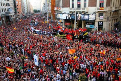 Los jugadores de la selección española, sobre un autobús descubierto, desfilan ante una muchedumbre congregada a lo largo de la Gran Vía de Madrid.