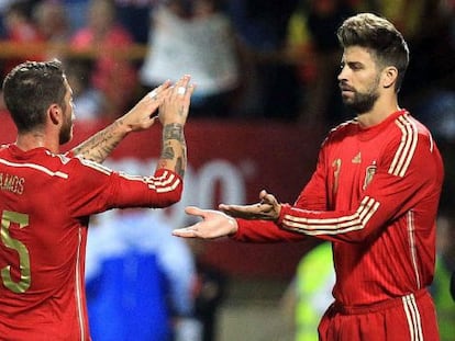 Gerard Piqué y Sergio Ramos chocan las manos en uno de los partidos que compartieron en la selección española.