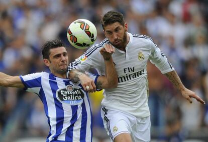 El jugador del Real Madrid Sergio Ramos disputa el bal&oacute;n con el delantero del Deportivo Helder Postiga.