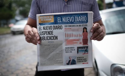 Un hombre muestra la primera plana de 'El Nuevo Diario' que anuncia la decisión del periódico de echar el cierre.