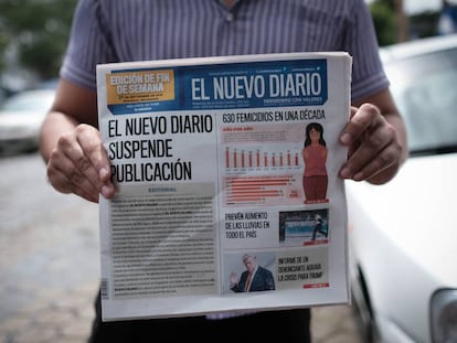 Un hombre muestra la primera plana de 'El Nuevo Diario' que anuncia la decisión del periódico de echar el cierre.