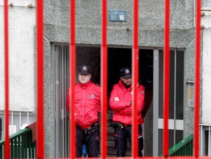 Agentes de la Ertzaintza cuestodian el portal de las v&iacute;ctimas.