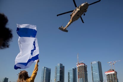 Una mujer sostiene una bandera israelí mientras un helicóptero del ejército con la soldado Agam Berger aterriza en el hospital Beilinson de Petah Tikva (Israel).