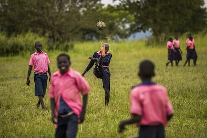 El deporte ocupa el tiempo libre de los niños después de la comida. Mientras los más pequeños se suben a los árboles a recoger frutos, juegan al escondite o simplemente se sientan a descansar, los mayores suelen organizar partidos en una tupida pradera a la entrada del colegio. Dos porterías de hierro combadas marcan el límite del terreno de juego. A veces juegan mezclados chicas y chicos, y otras por separado. Patean descalzos una pelota hecha de retales de tela o de ropa vieja. A menudo les basta con entrelazar tiras de plástico y darles forma esférica. En el centro de la imagen, Denish lanza el balón al aire durante un recreo.