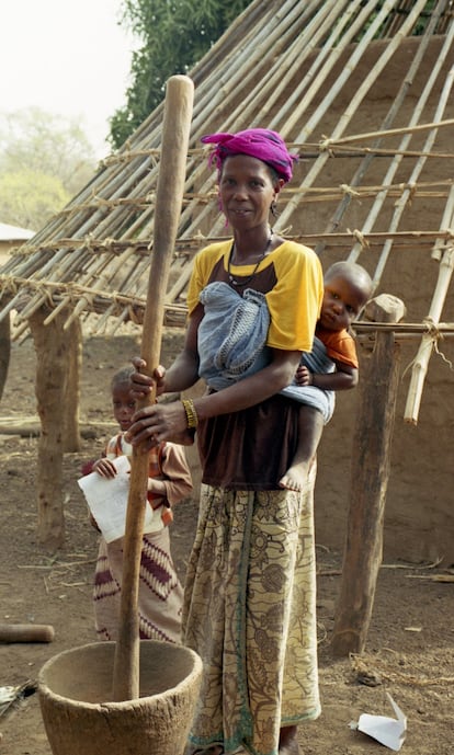 Denabu Dialo, de Nandoumary, muele cacahuetes mientras cuida de su bebé Yacaridiau. Un elevado porcentaje de mujeres en las áreas rurales tiene anemia, especialmente aquellas que están embarazadas.
