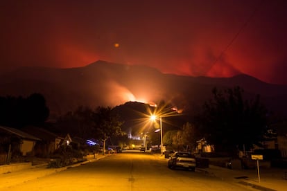 El fuego de Thomas se observa tras las viviendas en Ojai, California.