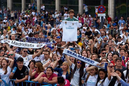 Aficionados del Real Madrid esperan la llegada de su equipo en la plaza de Cibeles.