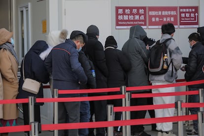 Un grupo de personas guarda cola frente a un hospital en Pekín para someterse a pruebas de coronavirus