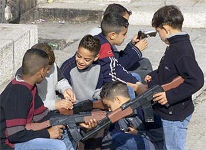 Niños palestinos prueban sus armas de juguete a las afueras de Jerusalén Este.
