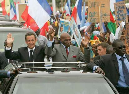 Nicolas Sarkozy (izquierda) y el presidente senegalés, Abdoulaye Wade, saludan durante un recorrido por la ciudad de Dakar.