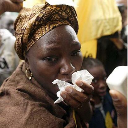 Una mujer africana muestra su dolor ante el edificio incendiado ayer en París.