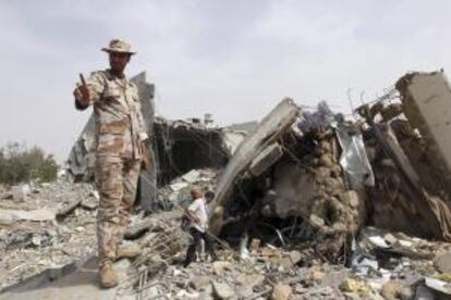 Un soldado libio inspecciona una zona destruida por la OTAN en las inmediaciones del palacio de Bab el Aziza, donde reside Gadafi, el 7 de junio