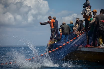 Pescadores de Tanga en alta mar recogen la red de pesca con decenas de atunes. 